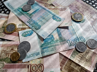 On the table are Russian rubles. Paper bills and metal coins fill the entire surface and create a background with money.