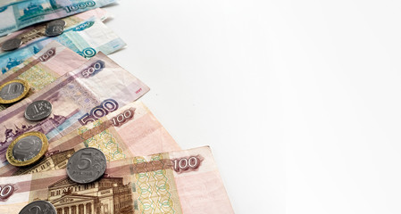 White background with Russian paper rubles and coins. To the right of the money there is room for text.