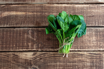 Clean food concept. Leaves of ripe juicy freshly picked organic spinach greens on a wooden...