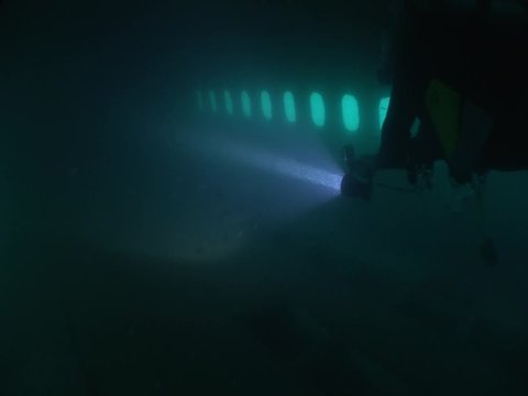 inside of a big airplane wreck underwater scuba divers to explore ocean scenery of wreck