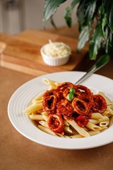 Authentic Mediterranean seafood pasta with tomato sauce. Greek main course dish photography on wooden table background.
