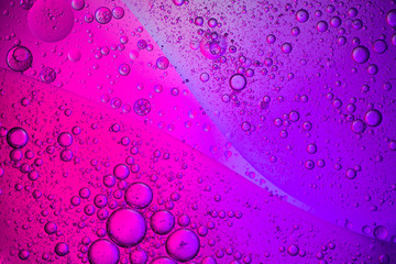 Abstract color background. Bubbles of oil in a colored liquid and lighting in macro photography....