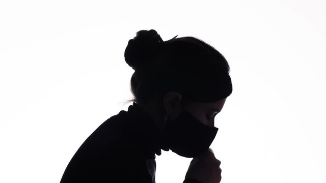 silhouette of the figure of a young woman in a protective mask coughing in hand on white isolated background, girl with symptoms of disease, health concept,world problem covid 19