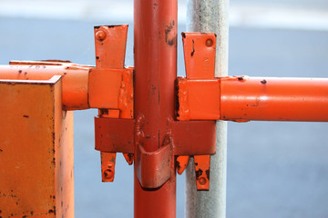 Close up of orange metal scaffolding connections on a building site in Australia