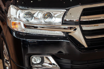 Obraz na płótnie Canvas Closeup of a car headlight. Headlight of an expensive new car at a car dealership.