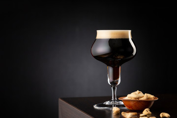 Cold dark beer and bowl of cashews