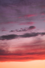 Summer sunset with pink-orange sky with clouds.