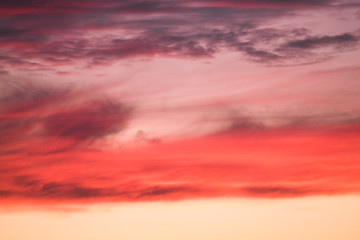 Summer sunset with pink-orange sky with clouds.