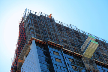 Top of a high rise construction site showing scaffolding, loading platforms and sky. Australia