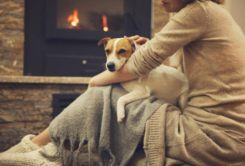 Cozy home, Woman and Dog relaxing near Fireplace. Carefree, comfort lifestyle.