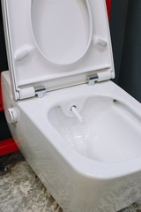 Toilet bowl with manual control bidet. Water sprays from the toilet bowl. A cleansing jet of water designed to cleanse the anus of the user of this bidet-style toilet.