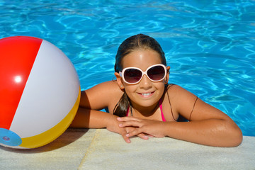 Real adorable girl relaxing in swimming pool