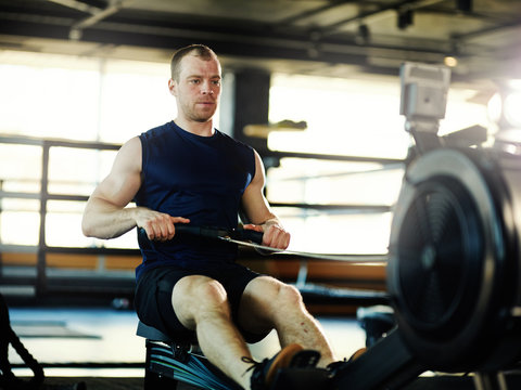 Determined And Middle Aged Man Doing Exercise On Rope Pull Machine In Gym