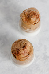 Dalgona coffee - the Korean coffee drink on light gray background.  Instant coffee or espresso powder whipped with sugar and hot water