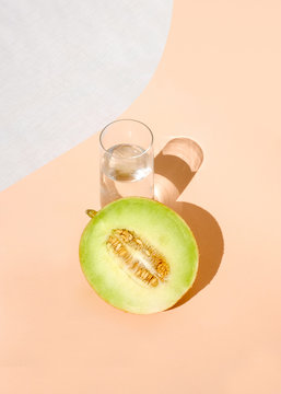 Overhead view of melon with glass of water on table