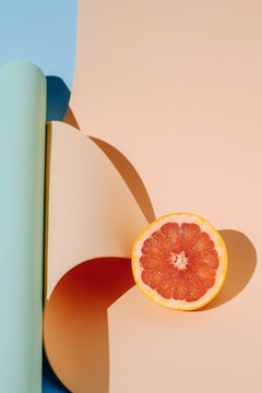 Overhead view of half pomelo on paper