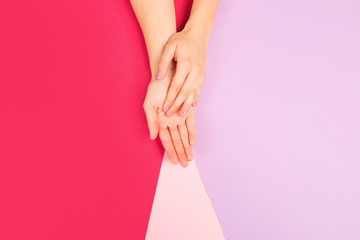 female  manicure. Beautiful young woman's hands on color pink  background - Image