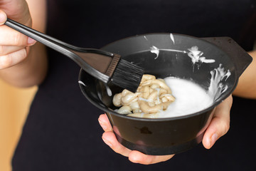 Tools for hair dyeing in woman hands. Colouring of hair at home