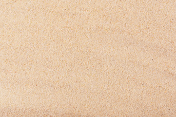 Gold sandy beach of seaside backdrop. Cute summer background with smooth surface. Sand texture. Empty place for text and design. Travelling and vacation concept