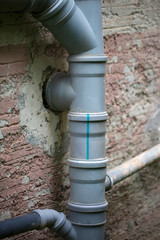Toilet drainage pipes with green grass growing around it