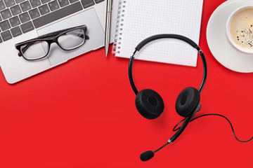 Office red workplace with coffee cup and headset
