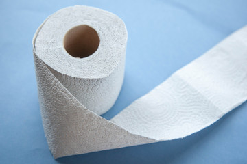 Unwinding toilet paper on a blue background. toilet paper deficiency coronovirus
