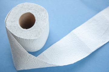Unwinding toilet paper on a blue background. toilet paper deficiency coronovirus
