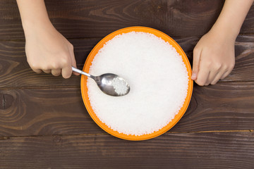 A child eats plastic pellets from a plate .Concept of environmental pollution with plastic