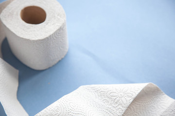 Unwinding toilet paper on a blue background. toilet paper deficiency coronovirus
