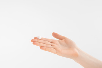 Hand cream on a woman's arm, droplet of cream. Woman applies cream on her hands isolated on grey background. Palm facing up.
