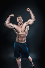 Fototapeta na wymiar Sexy young athlete posing on a black background in the Studio. Fitness, bodybuilding