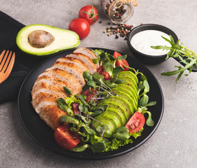 roasted sliced chicken fillet with avocado, tomatoes, sunflower sprouts on  plate healthy food