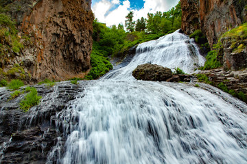 waterfall and rock with trees aunder sky