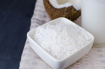 Coconut, coconut shavings and coconut milk on a black background. 