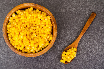 Sweet ripe canned corn in wooden bowl.