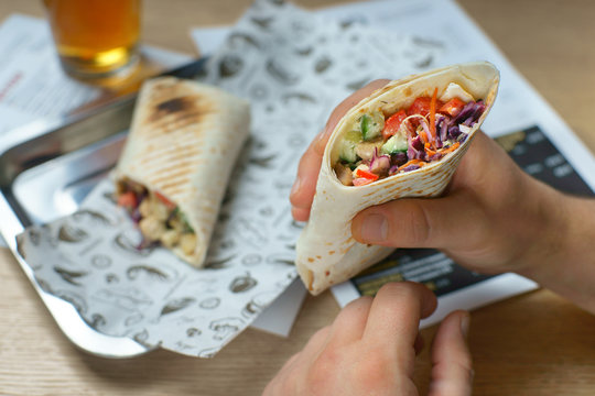 men's hands hold Shawarma with vegetables and chicken