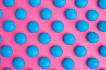Blue round chocolate candies on a pink background
