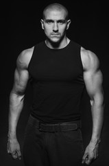 Sporty guy posing in the Studio on the background. Sports, beauty, black and white photography