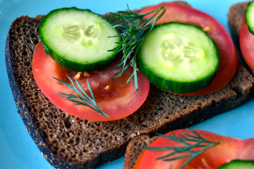 Diet sandwiches made of black flour with tomatoes and cucumber