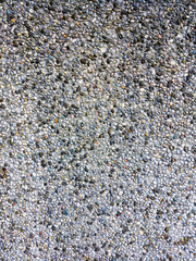 Background of colored pebbles in cement wall.