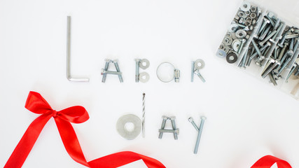 Different spare parts with red holiday bow on white background. Labor Day is a federal holiday of United States America.