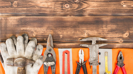 USA Labor day background concept. Repair equipment and many handy tools on a brown wooden background. Top view with copy space for use and design.