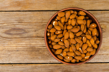 Lots peeled almonds in wooden bowl. Photo