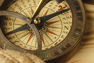 Fototapeta na wymiar Ship rope and compass on wooden background, close up