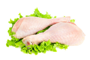 Raw chicken legs and green salad isolated on white background