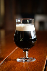 Glass of stout beer  on wooden table