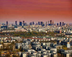 Fototapeta premium Beautiful panoramic aerial cityscape - view from the window of the plane landing at the center of Warsaw (Poland) with skyscrapers, with parks and residential areas, spring at sunset