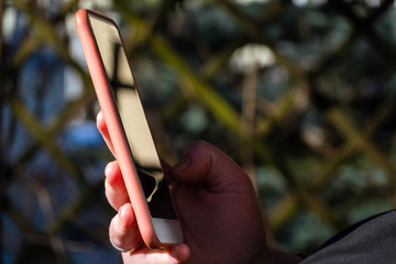 Close up of woman holding and texting with a smart phone. Girl typing message and chatting online