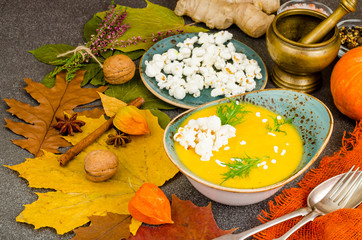 Seasonal pumpkin cream soup with popcorn. Photo