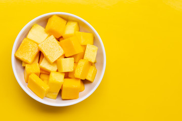Tropical fruit, Mango cube slices in white bowl on yellow background.
